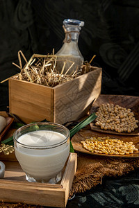 自然健康豆类产品一杯自制豆类牛奶和大的玻璃木盘上配有明晨照的木质面条状大豆替代牛奶概念选择重点农业图片