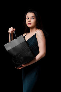 身着深绿裙子的年轻美女手里拿着黑纸购物袋在色孤立的背景下被困在她手上亚洲人美丽的最小图片