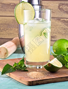 木制的柠檬石灰薄叶和夏季鸡尾酒冰莫吉托鸡尾酒配有石灰薄荷叶冰块和银盘寒冷的柠檬汽水图片