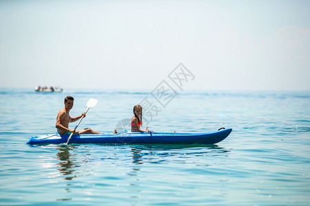 年幼的父亲和小孩在海上骑皮艇体育运动有吸引力的家庭在海上一起打皮艇幸福夏天图片