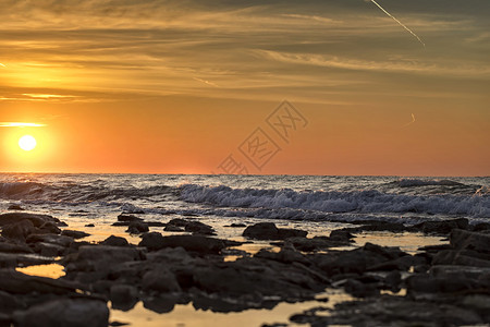 清晨长期照射海景水面有太阳和石块复制岩早晨图片