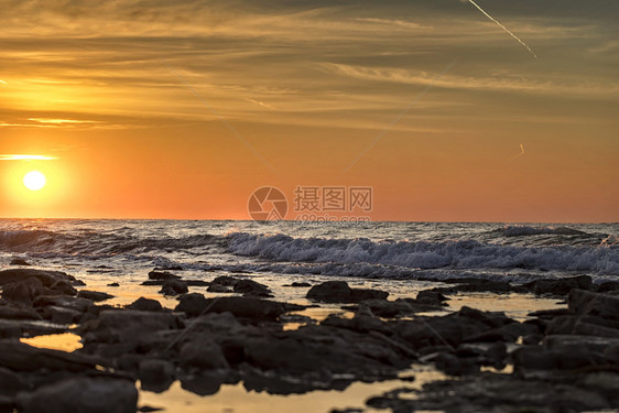 清晨长期照射海景水面有太阳和石块复制岩早晨图片