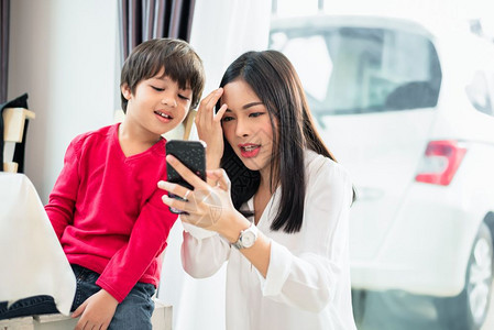 妈和她的孩子一起使用和调查智能手机人与技术概念教育和学习主题脸吸引人的白色图片