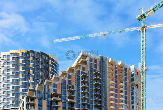 在蓝色天空和白云的背景下建造一座多层住宅大楼的建筑工地上单石框架级联混凝土结构和塔台起重机复制空间建筑工地一个多层住宅楼群建筑工图片