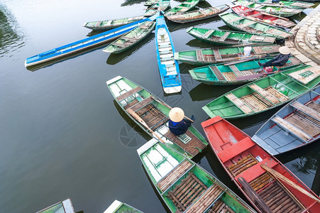 热带NinhBinh越南TamCoc河上一条传统船只坐着同冠的越南妇女旅行地貌和目的运输越南语图片