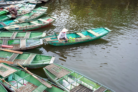 地标宁运输NinhBinh越南TamCoc河上一条传统船只坐着同冠的越南妇女旅行地貌和目的图片