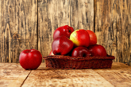 作品维他命橙红熟苹果放在木制背景的旧桌上柳条篮里图像有复制空间红熟苹果放在旧木桌上的柳条篮里图片