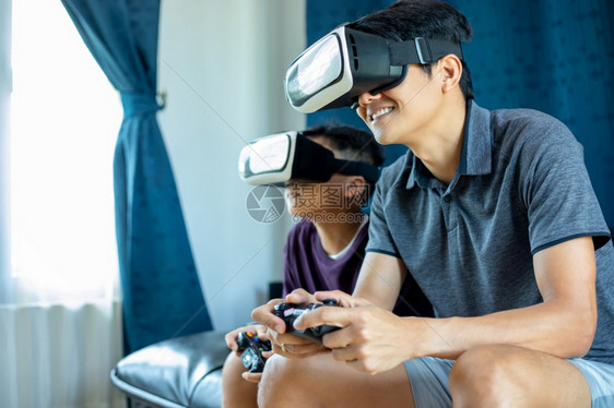 亚洲人父亲和儿子在家中客厅享受游戏与视频玩棍和虚拟现实眼镜一起玩游戏令人振奋非常有趣的娱乐技术激动图片