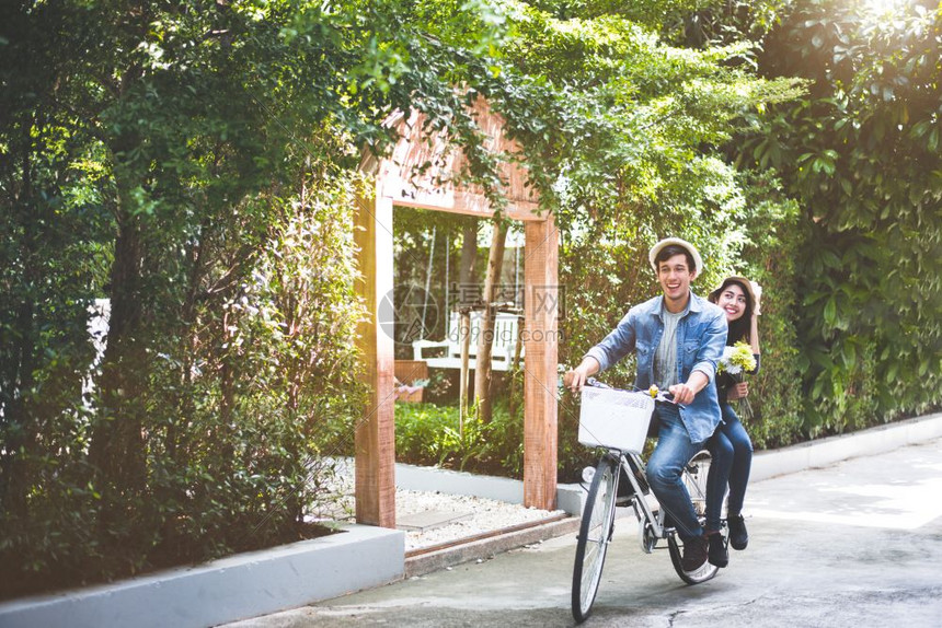 合身白种人快乐的一对夫妇在浪漫观下一起骑自行车在公园背景华伦人节和婚礼蜜月概念中一起骑车人与生活方式概念西班牙裔图片