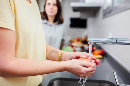 白天积极妇女准备健康食品在厨房里清洗一些蔬菜享受娱乐和饮食概念的营养妇女在厨房里做健康食物和洗菜涤图片