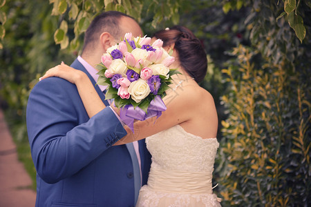 庆典新郎手上漂亮的婚礼花束在新娘手上接吻仪式已婚图片