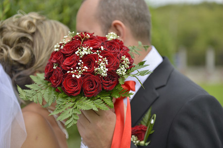 家庭新人浪漫郎手上漂亮的婚礼花束在新娘手上接吻图片