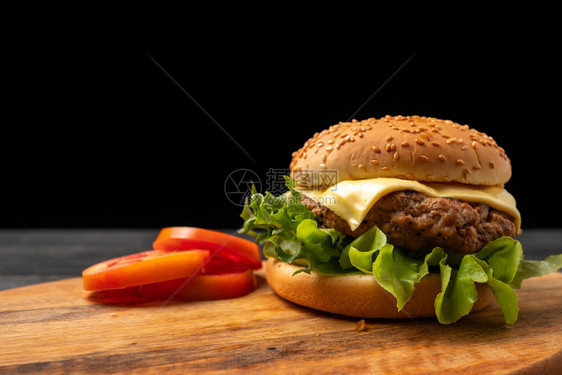 美味的木板垃圾鲜新的自制汉堡包菜生番茄芝士和切西红柿一起在割板上图片
