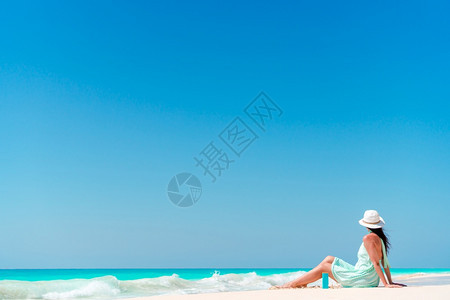 在海滩度假的年轻快乐女人放松躺在海浪中穿着比基宁在海滩上波浪目的地游客图片