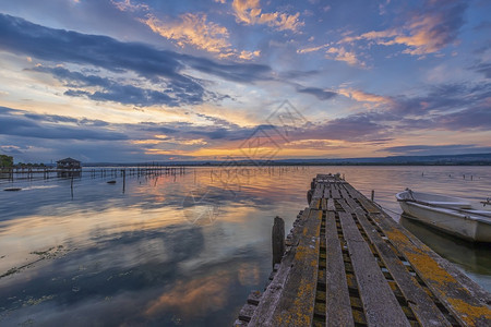 冷静的感人日出在湖边木码头上乘船日落着令人惊异的心情图片