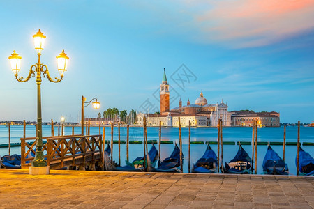 威尼斯的城市景象在意大利与贡多拉斯在日出时城市景观著名的水图片