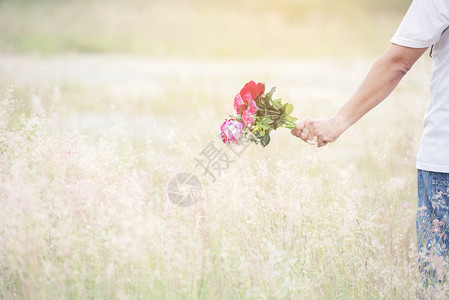 淑女幸福开花一个微笑的年轻男人肖像带着一束玫瑰花朵门外有草地图片