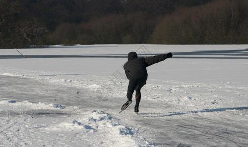 北极滑冰冻结男孩在冬的Holland中快速滑动图片