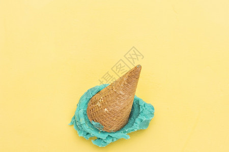 黄色背景的蓝冰淇淋锥甜点马卡龙曲奇饼图片