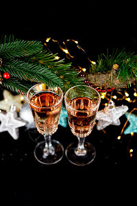新年和圣诞装饰香槟酒杯圣诞树玩具站在黑暗中前面的桌子上背景美丽的散特写顶视图新年和圣诞装饰香槟酒杯圣诞树架玩具在黑暗中前面的桌子图片