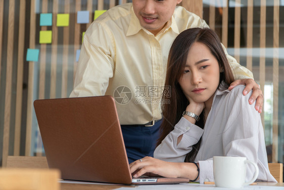 经理女商人们在工作时把手放办公室女员工的肩膀上她对老板的不当行为感到满和工作场所骚扰的概念图片