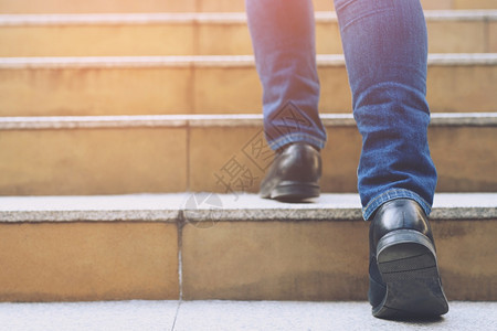 运动积极的一个人走在现代城市的楼梯上去成功长大后用过滤器托恩旧古老的热效应梯子从高空爬上楼梯图片