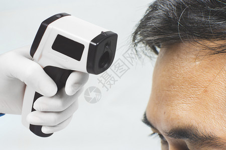 使用电子测温枪测温的男性图片