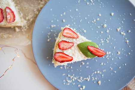 美味的起司鲜草莓和罗勒叶装饰的鲜亮芝士蛋糕在盘子上切一块鲜草莓和罗勒叶装饰的鲜芝士蛋糕在盘子上切一块生日图片