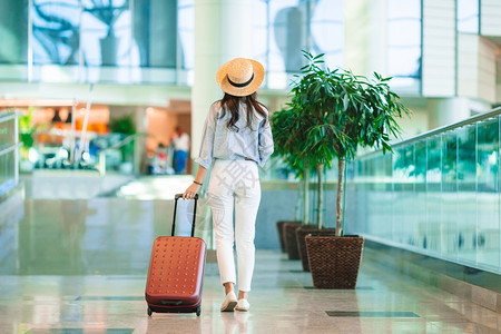 国际机场带行李的年轻女子国际机场带行李的戴帽子年轻女飞成人自由图片