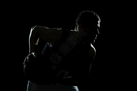 青年肌肉发达剪影篮球运动员拿着黑色背景高分辨率照片剪影篮球运动员拿着黑色背景高质量照片跳图片