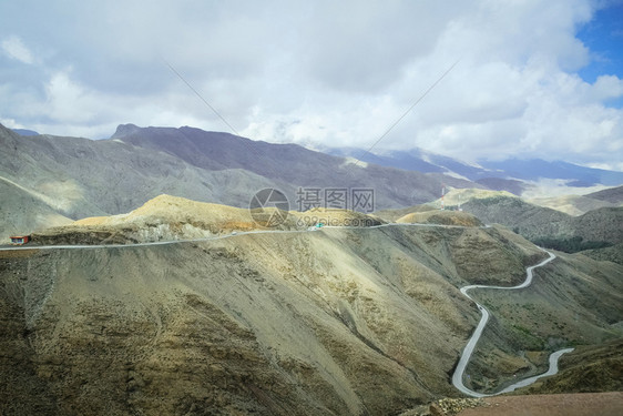 风景优美沿阿特拉斯山脉绕行道路与多云的蓝色天空对抗景观图摩洛哥蓝色的荒野图片