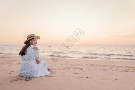 海滩上快乐的亚洲年轻女子看着摄影机在日落背景下旅行度假暑期吸引人的晒黑图片