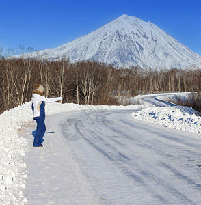 女孩搭乘在火山对面的冬季公路上外部的闲暇人们图片