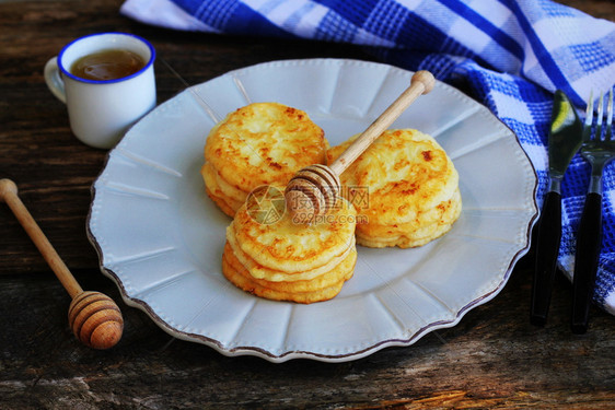 木黑背景上堆满煎饼和蜂蜜糖浆枫可丽饼甜点图片