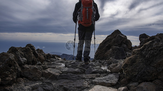 装备齐全的徒步在岩石山路上行走徒步旅积极的自由图片