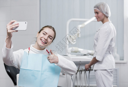 快乐的年轻女子自牙医约定笑微图片