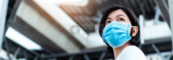 身戴蓝色保护面罩的亚洲青年妇女在前往城市户外工作时向望去佩戴科面具的女以保护空气污染和流行病共食19Banner感染过敏旅行图片