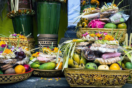 向印度尼西亚神灵赠送传统祭品在寺庙中献花水果和香棒向印度尼西亚神教徒献送佛巴厘传统祭品在寺庙里献花水果和香棍牺牲供品上帝图片