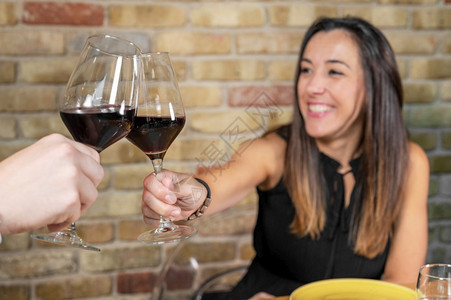 饮料在餐厅用红酒杯烤面包高品质照片在餐馆用红酒杯烤一对年轻夫妇的烤面包在餐厅用红酒杯烤一对小夫妇水平的晚餐图片