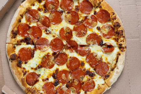 美食盒装味纸多尼披萨的顶视图意大利食品街头快餐的概念盒子里美味纸多尼披萨意大利食品快餐的概念纸多尼披萨的顶部视图意大利辣香肠食物图片
