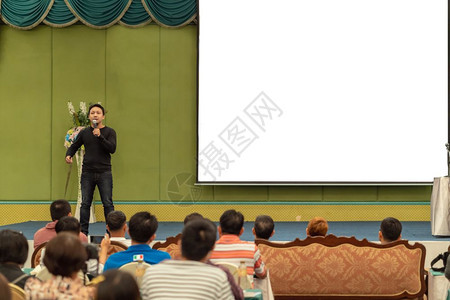 专业的亚洲人讲话演在舞台上有临时穿便装的亚洲演讲人在大会堂或研讨商业和教育概念上播放屏幕专题发言图片