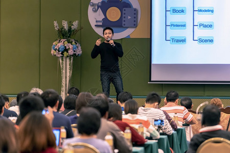 首脑人们亚洲演讲在舞台上有临时穿便装的亚洲演讲人在大会堂或研讨商业和教育概念上播放屏幕专题发言扬声器图片