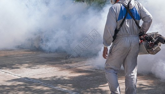 使用雾机喷洒化学品以消除蚊虫和防止公共场所登革热的防护服室外保健工作者中产体身着保护服的户外健工作者卫生机器多雾路段图片