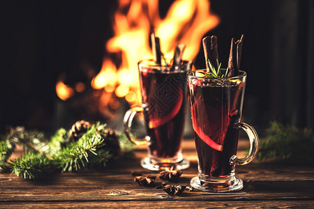 在火炉灾的背景下在圣诞节假日传统冬季饮酒时木制桌上的边装有玻璃杯中调味品的混合葡萄酒柑橘壁炉舒适图片