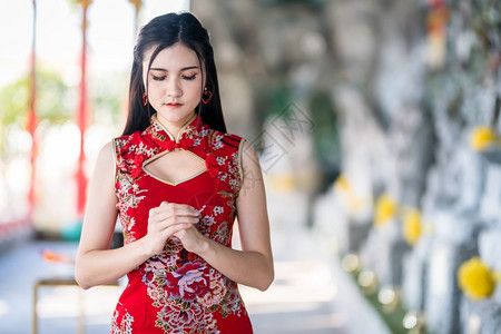 亚洲人旅行游客身着新年节在泰中神庙举办新年庆典红传统香藏装饰的亚裔年轻女子她的长相笑脸如肖像般美丽图片