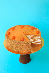 在木制蛋糕摊上剪切的生日蛋糕美丽的海绵蛋糕配着鲜奶油棕榈和花粉的美海绵蛋糕蓝色背景复制空间食物摄影作为谱木制的酸浆可口图片