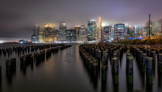 市中心日落时在布鲁克林桥的哈德逊河上纽约天线反射降低大都市图片