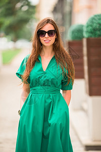 魅力裙子步年轻女在城市户外行走在城市穿绿衣服的年轻女子图片