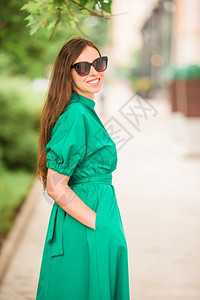 镇年轻女子在城市户外行走在城市穿绿衣服的年轻女子全套服装人们图片