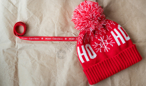 礼物12月5日红丝带上印有圣诞快乐和红色帽子在工艺纸上展开圣诞节概念12日红丝带上印有圣诞快乐和红帽子一种白色的图片